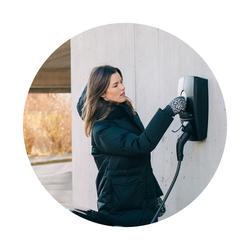 Kvinne lader elbil med elbillader