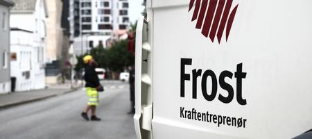 Logo til Frost Kraftentreprenør på lastebil. Mann i arbeidsklær i bakgrunnen.