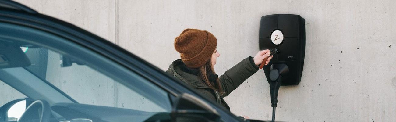 Kvinne lader elbilen sin med Zaptec Go lader